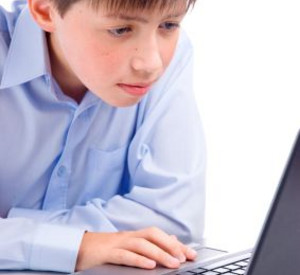 Junge sitzt vor Laptop Foto: isirius r © Stockphoto.com